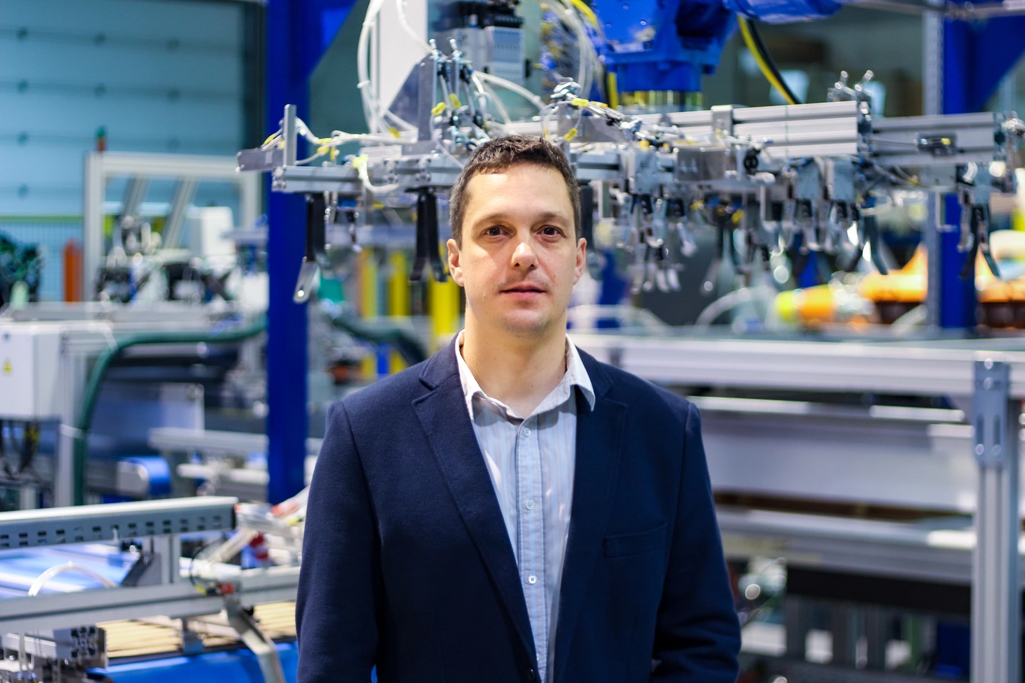 Gregor Brajović in front of industrial automation equipment