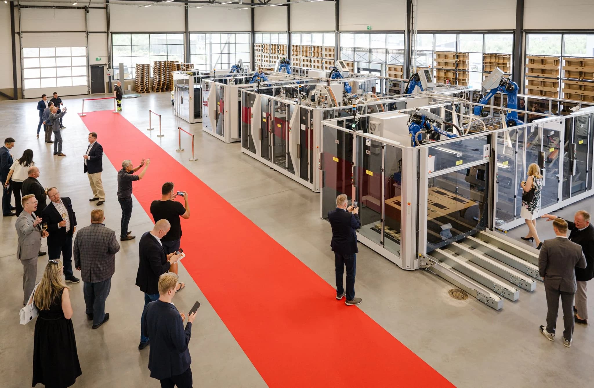 Visitors and engineers gathering around KraftPal manufacturing equipment